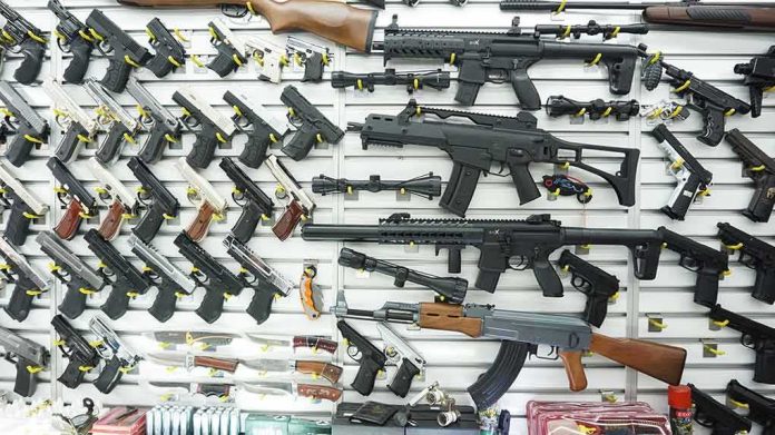 shutterstock_1096565825 Wall display of assorted firearms in a gun shop