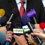 Florida AG Targets Fauci With Blistering Pardon Question Press microphones surround a suited spokesperson