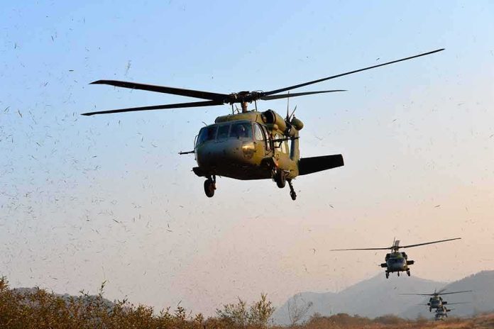 shutterstock_1159121266 Military helicopters flying low over a dry landscape