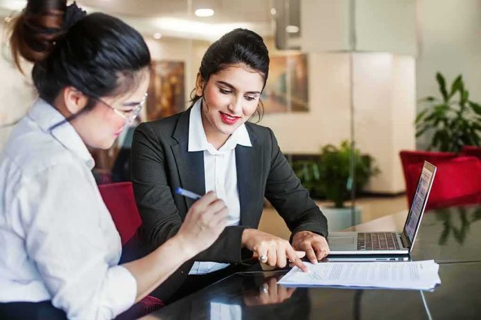Two businesswomen reviewing documents at a desk