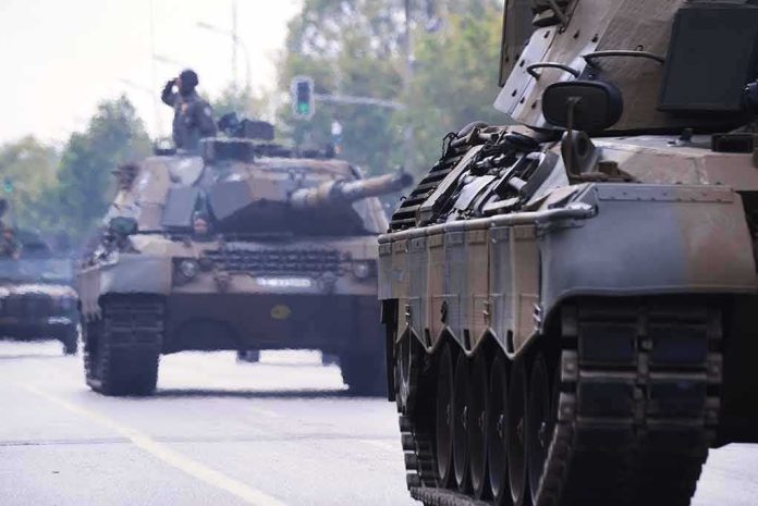 shutterstock_1200057271 Military tanks drive down a city street