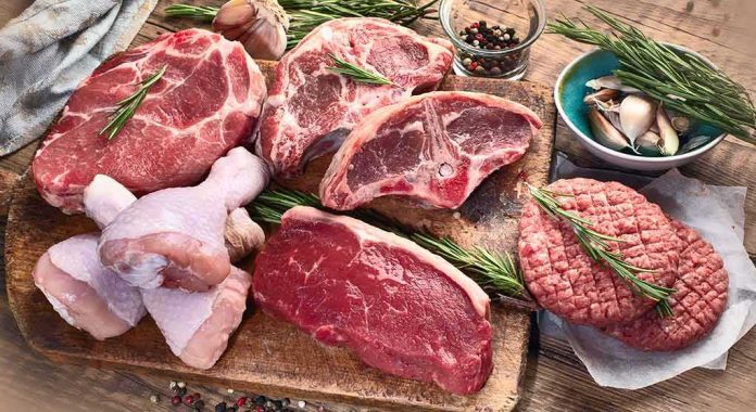 shutterstock_1214133751 Assorted raw meat cuts with herbs on a wooden board