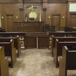 Kyrsten Sinema Allegedly Bailed Boyfriend Out After Assault Arrest Interior view of an empty courtroom with wooden benches and a judges bench