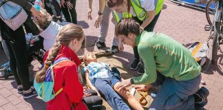 First aid trainees practice on a child manikin outdoors