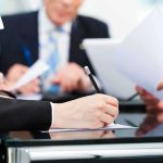 Why 2028 Could Bring a GLOBAL Financial Reckoning Close-up of a hand writing notes during a business meeting
