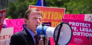 Man speaking into a megaphone at a rally