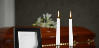 Memorial frame and candles with a casket in the background