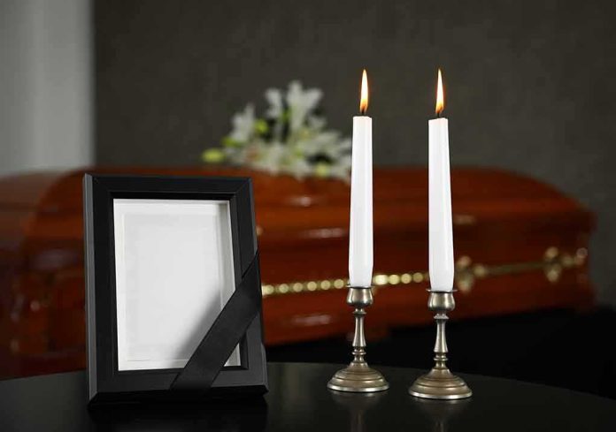 Memorial frame and candles with a casket in the background