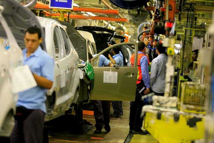 shutterstock_1599170338 Teddy Williams on an automotive assembly line with workers fitting car doors