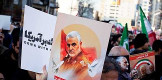 Protesters holding posters of Qasem Soleimani and Abu Mahdi al-Muhandis