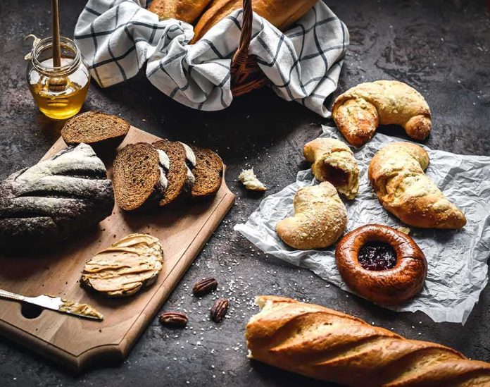 shutterstock_1665323011 Assorted breads and pastries on a dark rustic surface
