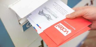 Hand dropping mail-in ballots into a drop box