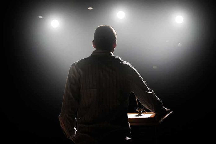 shutterstock_169681064 Speaker on stage under bright spotlights