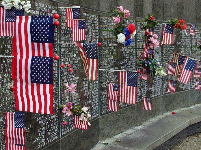 shutterstock_17555125 Memorial wall adorned with American flags and flowers
