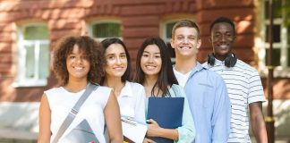 Group of students standing outdoors with notebooks