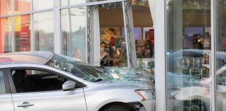 Silver car crashed into storefront window