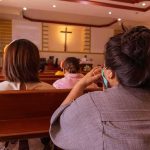 James Talarico’s Pastor DENIES Jesus Died For Sins people seated in church pews facing a cross