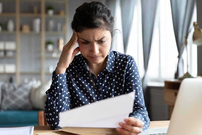 shutterstock_1835827372 Woman reading a document with a worried expression