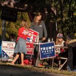 Lawmakers Warn These ‘TROJAN HORSES’ Could Take Down America People at a political campaign table with signs and flyers outdoors