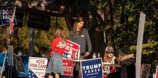 Lawmakers Warn These ‘TROJAN HORSES’ Could Take Down America People at a political campaign table with signs and flyers outdoors