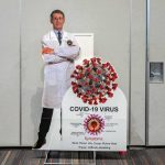 White House Backs Anti-Vax Crowd? Cardboard cutout of doctor with COVID-19 virus info display