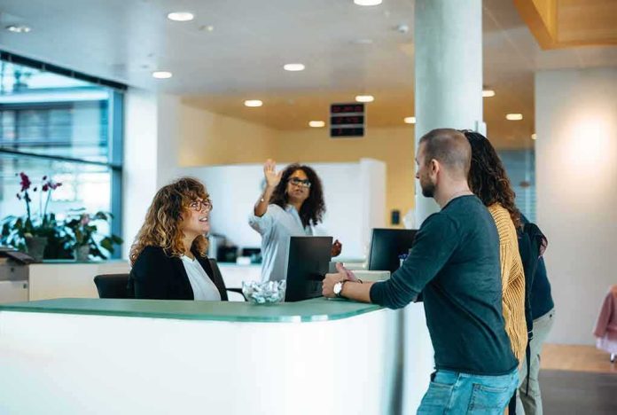 shutterstock_1953564844 Reception desk with staff assisting visitors