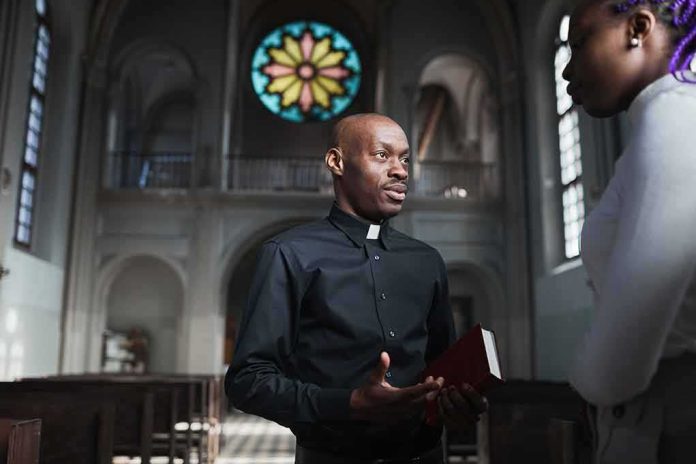 shutterstock_1962860494 Priest speaking with a visitor inside a church
