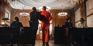 Insanity Defense Drama Collides With Cold Evidence Prisoner in orange jumpsuit escorted by officer in a courtroom