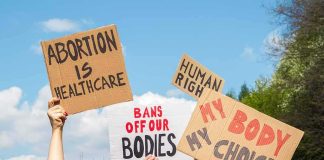 Graphic ‘Abortion’ TV Campaign Puts Trump on the SPOT Protesters hold cardboard signs at a rally outdoors