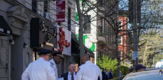 police officers and investigator at a taped-off city sidewalk