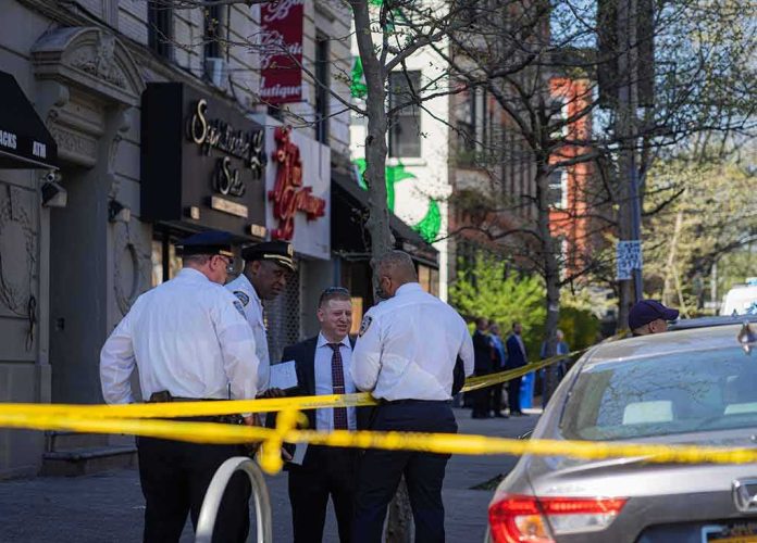 police officers and investigator at a taped-off city sidewalk