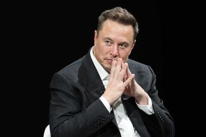 shutterstock_2318800287 Elon Musk seated in a dark setting with hands steepled near his face