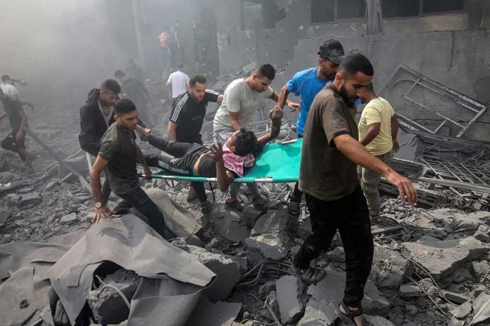 shutterstock_2374212961 Rescuers carry an injured person on a stretcher through rubble