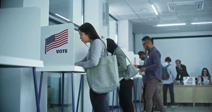 shutterstock_2451104741 Voters at polling booths in a modern voting center