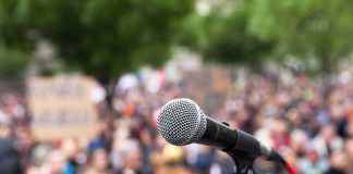 microphone on stand in front of a blurred crowd