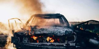 Burning car with doors open and flames in the cabin