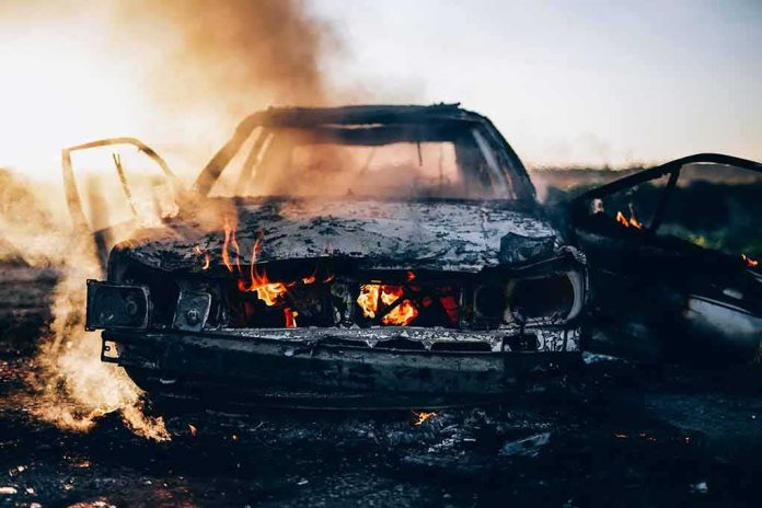 shutterstock_526837102 Burning car with doors open and flames in the cabin