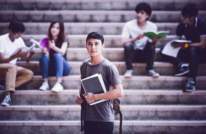 Student holding notebooks on campus steps