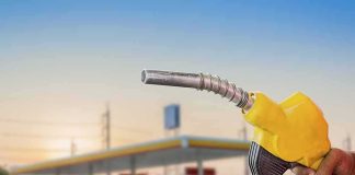 Yellow fuel nozzle held at a gas station