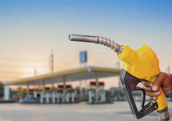 Yellow fuel nozzle held at a gas station