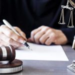 FBI Raids Swalwell’s Home, Seizes His Electronics Judge writing at desk with gavel and Lady Justice statue