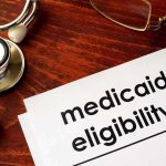 Medicaid eligibility form with stethoscope and pen on desk