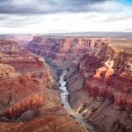 Grand Canyon: Rescue Choppers Race the Surge Grand Canyon with river winding through layered red cliffs