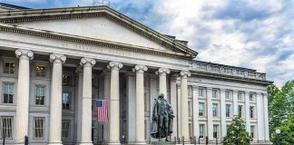 Neoclassical government building with columns and a central bronze statue