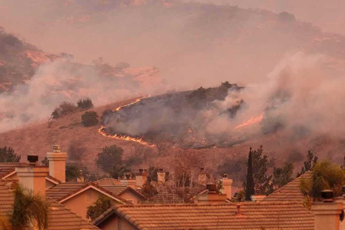 shutterstock_735803347-1 Wildfire burns on hillside near suburban homes