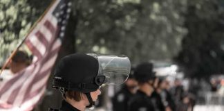 police officer in riot gear standing in a line