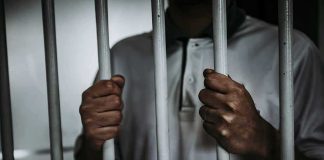 Tupac’s Killer Claims He’s CHANGED Person gripping prison bars with both hands