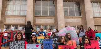 Cornell Scandal Ignites NATIONWIDE Fight Students holding protest signs on school steps