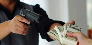 Hundreds of Armed Robberies Were FAKE person aiming handgun while another hands over bundles of cash
