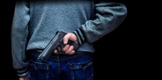 Transgender Suspect Tied to Canadian Mass Shooting ARRESTED person holding a handgun behind their back